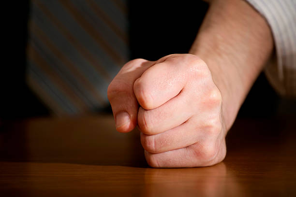 Businessman hitting table with clenched fist.