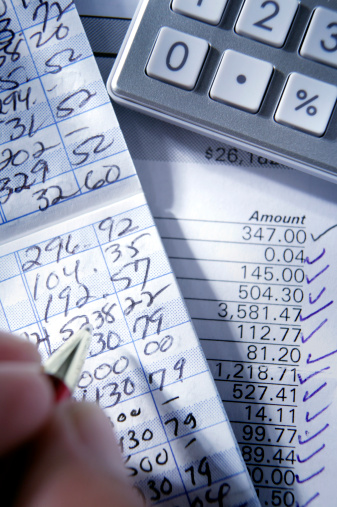 Close up of calculator and bank statement while balancing checkbook