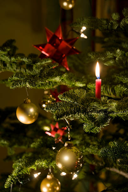 istock Christmas tree with gold baubles and red lit candle 183278093
