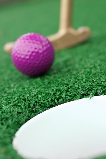 Miniature golf; very narrow depth of field, focus on the back of the cup.