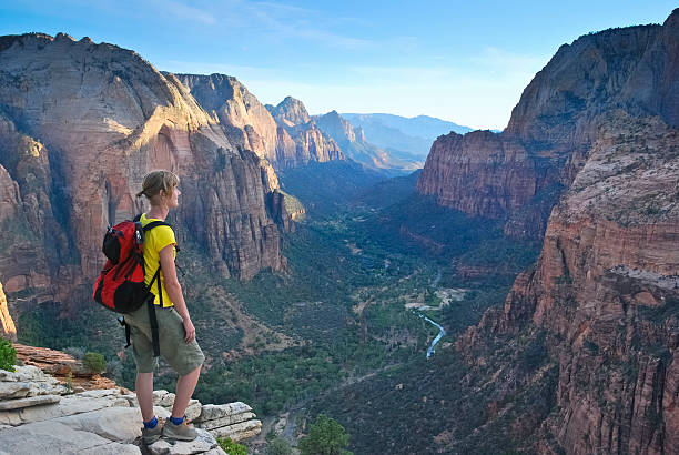 A woman looks out to Zion Canyon from the top of Angels Rest in Zion National Park, Utah.