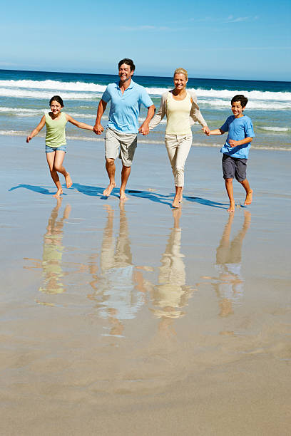istock Joyful family running along the beach 183279442