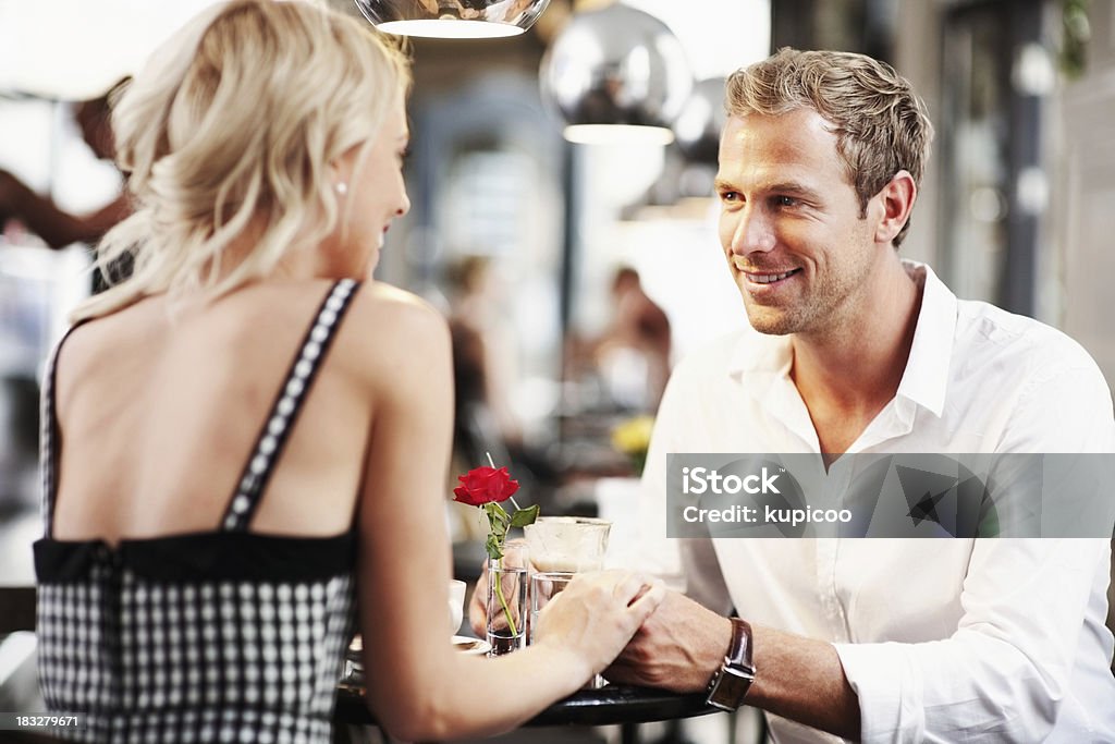 Romantica giovane coppia avendo buon tempo presso una caffetteria - Foto stock royalty-free di Abbigliamento casual