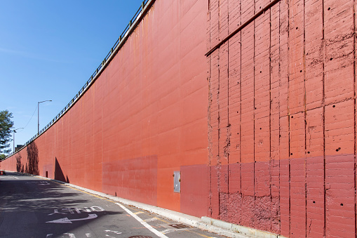 Image filling view of the curved concrete red colored façade and ramp of the Brooklyn-Queens Expressway from Hicks Street, Brooklyn Heights, New York giving abstract
