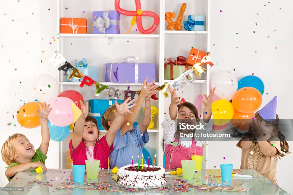 Feliz grupo de niños disfrutando de confeti en fiesta de cumpleaños - Foto de stock de Niño libre de derechos
