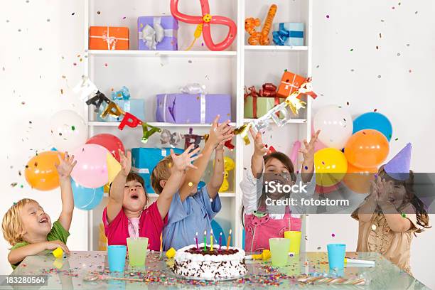 Feliz Grupo De Niños Disfrutando De Confeti En Fiesta De Cumpleaños Foto de stock y más banco de imágenes de Niño
