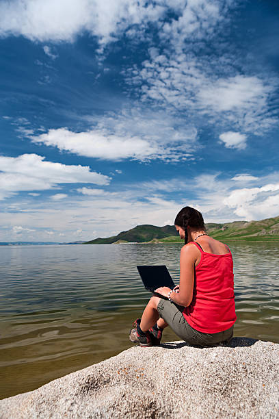 istock Young woman with laptop on the rock 183280962