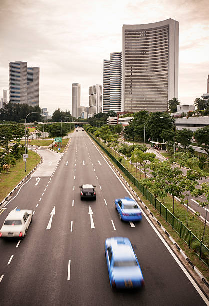 Taxis and cars driving downtown in Singapore City.