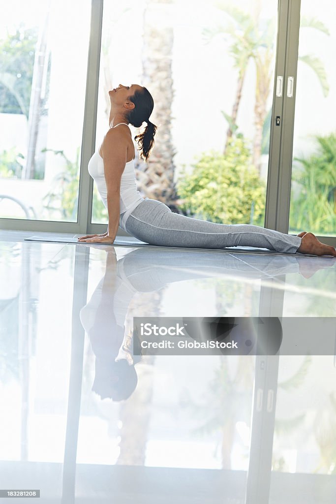 Meio envelhecido mulher fazendo exercícios de ioga chamado Surya Namaskar - Foto de stock de 20 Anos royalty-free