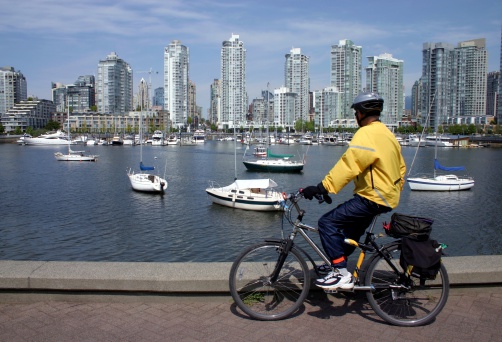 Cyclist stops to take in view of False Creek in Vancouver, Canada.