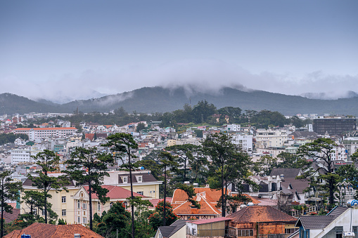 Dalat city, Vietnam - 02 Dec 2023: View on roofs in the city of Dalat. Da Lat and the surrounding area is a popular tourist destination of Asia. City with fogs and mountains