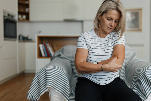Elbow pain Mid adult woman having elbow pain joint pain stock pictures, royalty-free photos & images