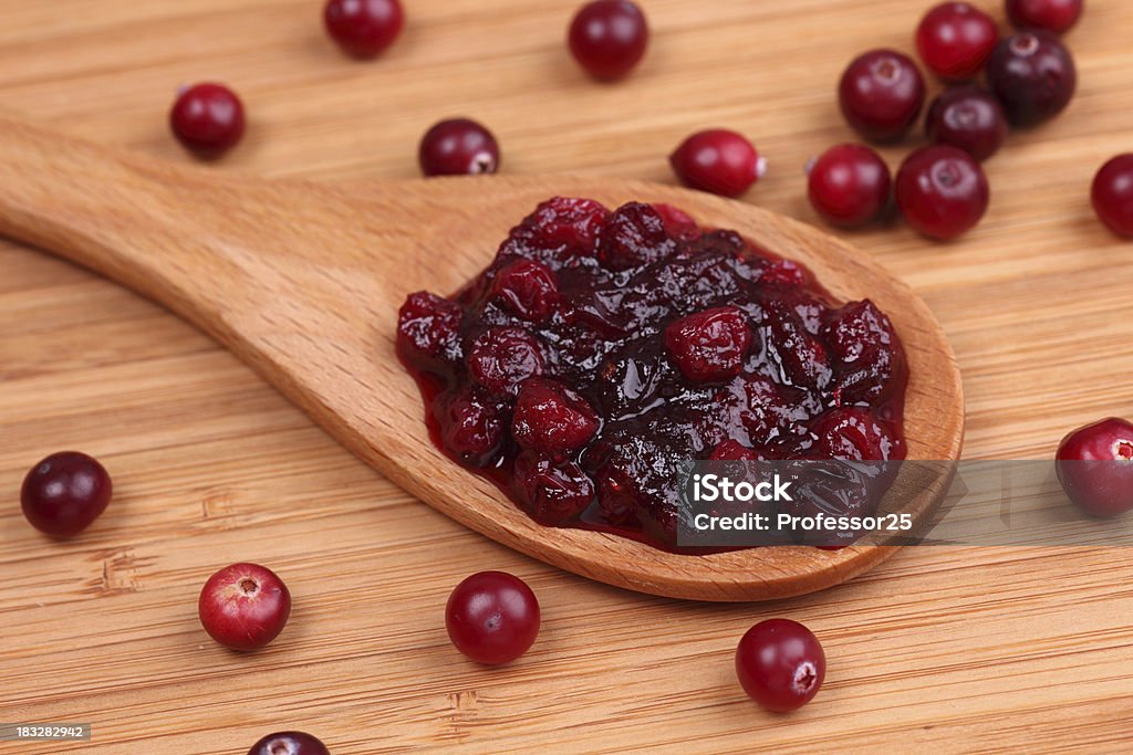 Salsa de arándano en una cuchara de madera - Foto de stock de Arándano rojo - Fruta baya libre de derechos