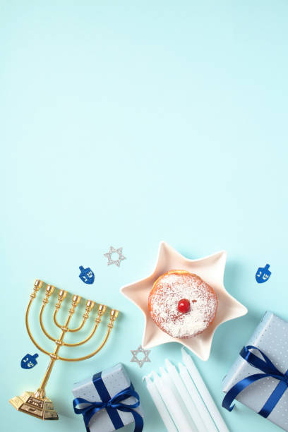 istock Hanukkah holiday vertical banner. Flat lay composition with menorah, gift box, candles, david star shaped plate with jelly donut on blue background. 1832834701