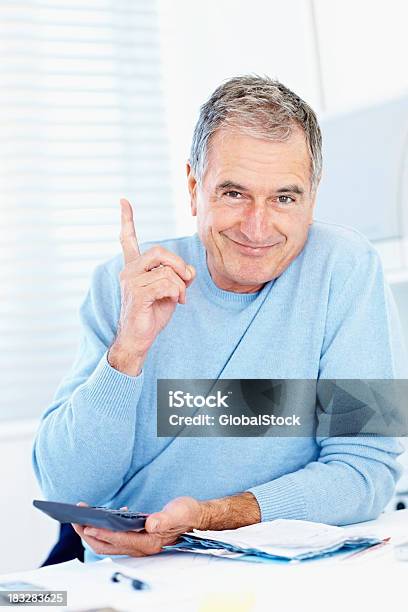 Old Man With Calculator And Bills Pointing At Copy Space Stock Photo - Download Image Now