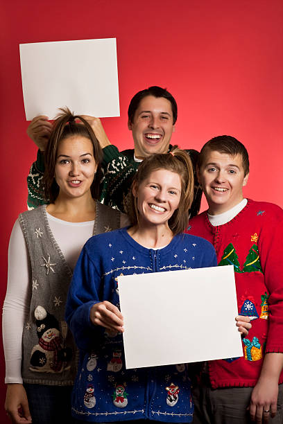 Two signs Christmas sweater group A group of adults in ugly Christmas sweaters holding blank signs christmas ugliness sweater nerd stock pictures, royalty-free photos & images