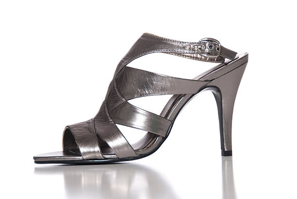 High Heel A grey metallic high heeled shoe on a white background. gladiator shoe stock pictures, royalty-free photos & images