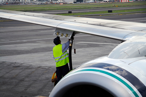male worker fueling jet airliner