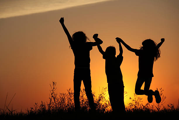 istock Silhouette of Three Happy Children Jumping Outside 183284912