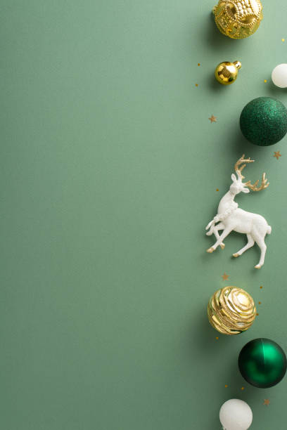 Magical New Year setting. Vertical top view capturing deluxe baubles and festive reindeer. Gold sequins create magical ambiance on light green background, providing space for personalized wishes or ad