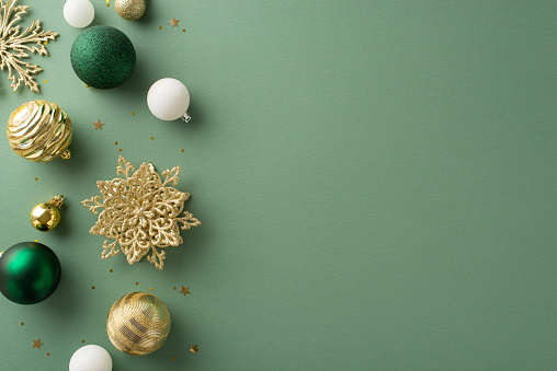Refined festive atmosphere. Top-down view of luxurious Christmas ornaments, snowflake details, glistening gold sequins on a subtle green background with space for well-wishes or advertising