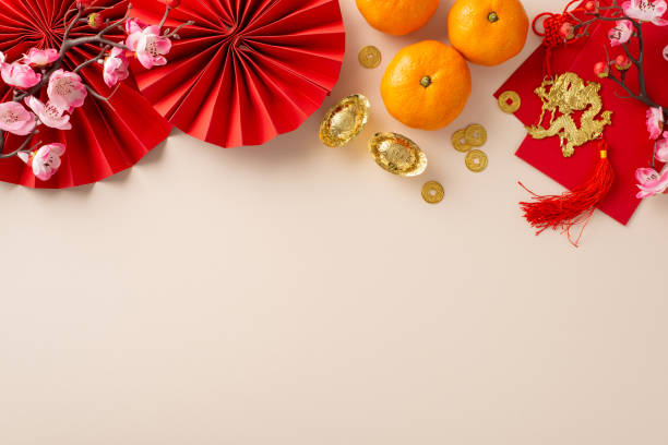 istock Infuse your Chinese New Year celebration with elegance using this picturesque arrangement. Top view of fans, Feng Shui trinkets, symbolic elements on pastel backdrop, leaving space for festive message 1832851594
