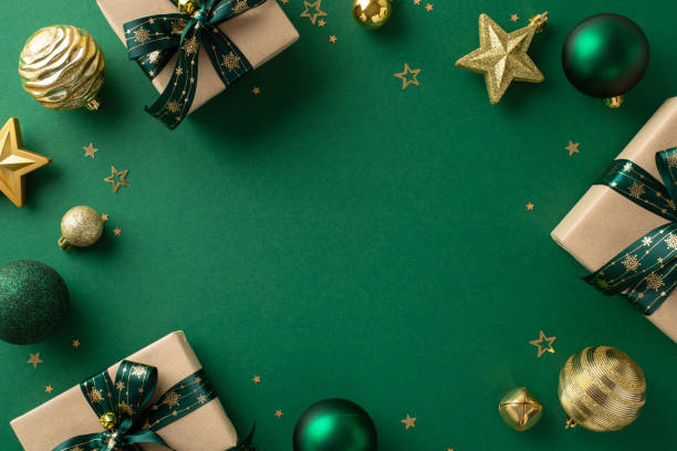 istock Crafting Christmas joy: Top-down view capturing craft paper gift boxes, luxurious baubles, glittering star ornaments, jingle bell, and golden confetti on a joyful green background 1832852112