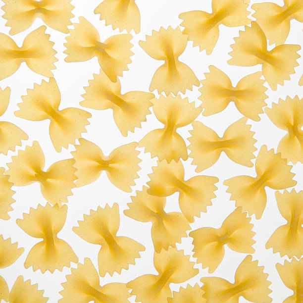 makaron farfalle zbliżenie na białym tle - bow tie pasta italian cuisine bow heap zdjęcia i obrazy z banku zdjęć