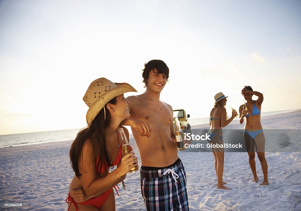Couple et leurs amis d'une bière en jeep en arrière-plan - Photo de Coucher de soleil libre de droits