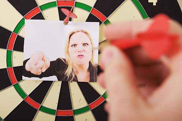 Business Woman Dart Board a person ready to throw a dart at a angry business woman boss. woman darts stock pictures, royalty-free photos & images