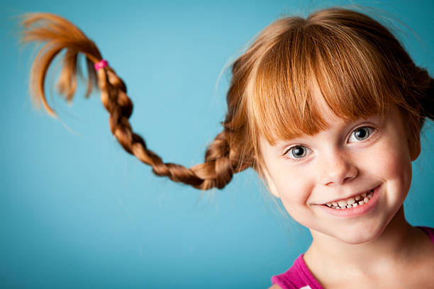 Red-Haired Girl with Upward Braids and a Big Smile stock photo
