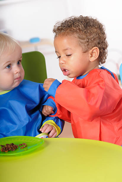 istock Biracial Baby/ Toddler Interacting With His Peer During Mealtime 183286402