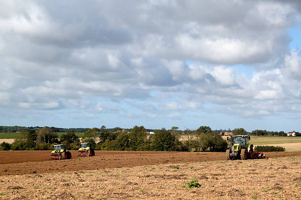 istock Three tractors ploughing a field in September 183286954