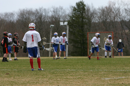 Lacrosse match, players, gear on the field, american sports themed photograph.