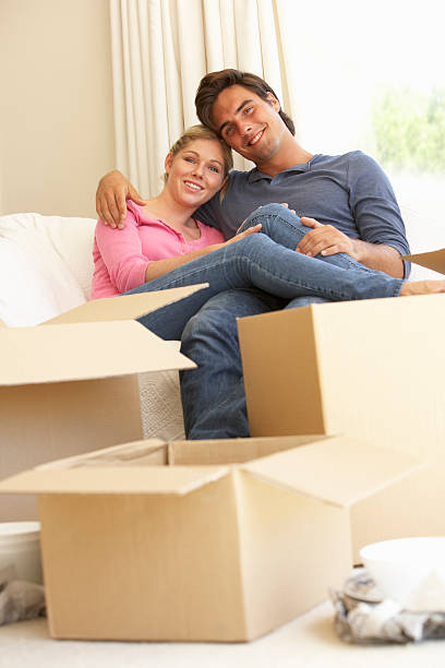 istock Young Couple Moving Into New Home Surrounded By Packing Boxes 183287635
