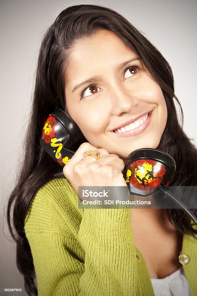 Happy Young Woman Using Funky Telephone Happy Young Woman Looking Up and Smiling While Using A Funky Telephone.More from this series: Achievement Stock Photo