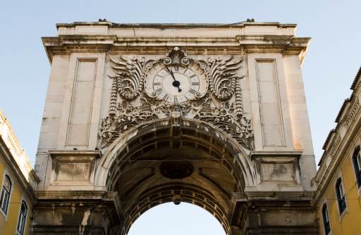 Low angle view of the clock on the Triumphal arch at the entrance of commerce square (pra