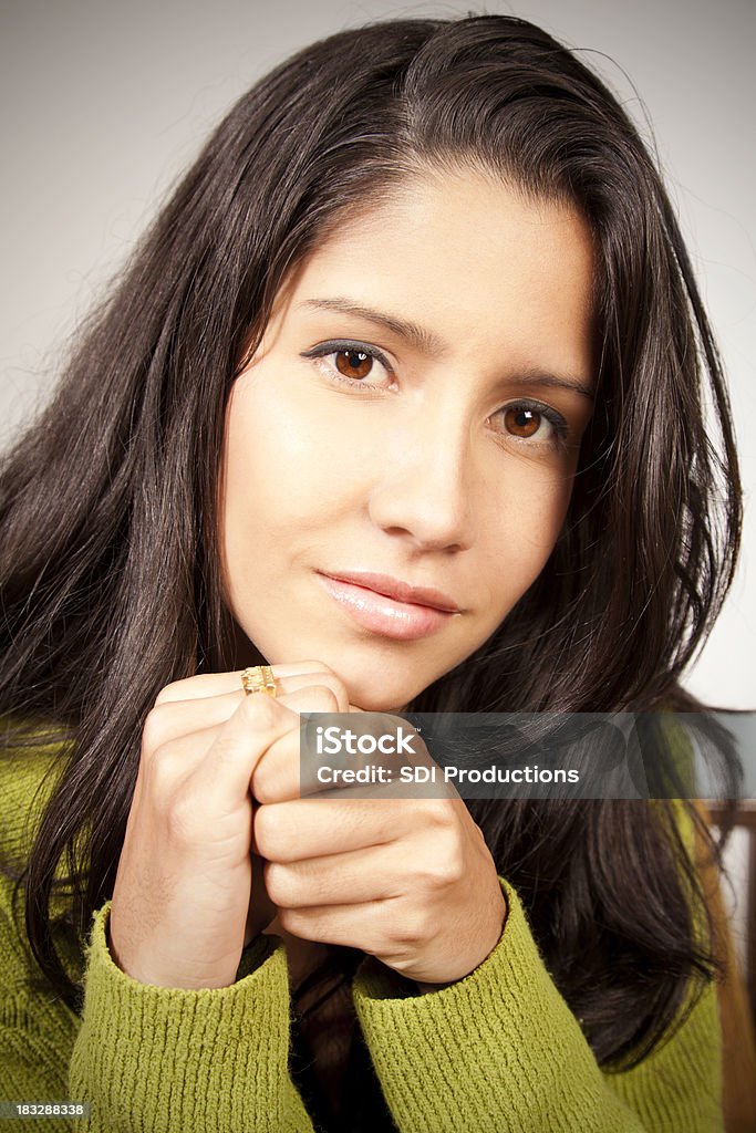 Content Young Woman Holding Hands And Looking Forward Beautiful Content Woman with Long Dark Hair Folding Her Hands. Isolated On White. More from this series: Adult Stock Photo