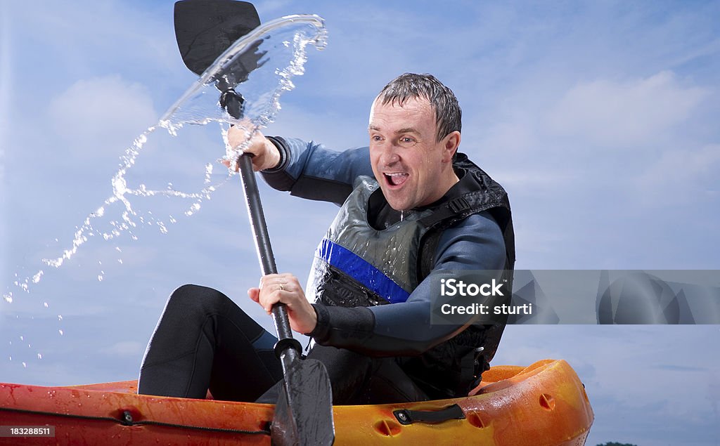 Man Kayaking Through Rough Waters Man excitedly paddles his kayak through a spray of water. Kayak Stock Photo