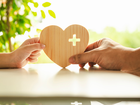 Businessman holding heart icon with his child, Security protection and health insurance. The concept of family home, protection, health care day, car insurance and home school education.