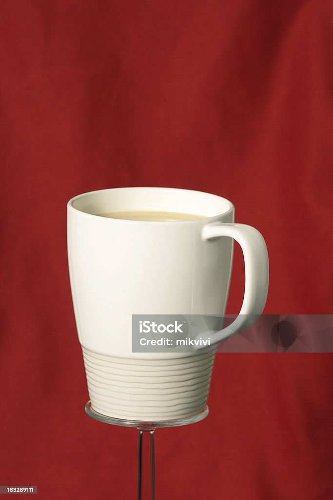 Coffee Cup White ceramic coffee cup on a glass pedestal with red background. Ceramics Stock Photo