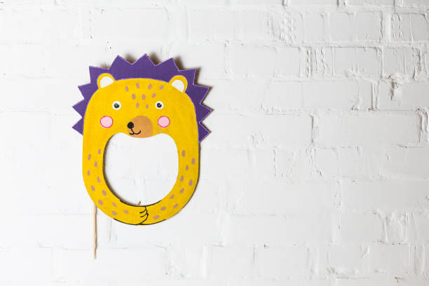 istock Bright cardboard mask on a white brick wall. 1832891772