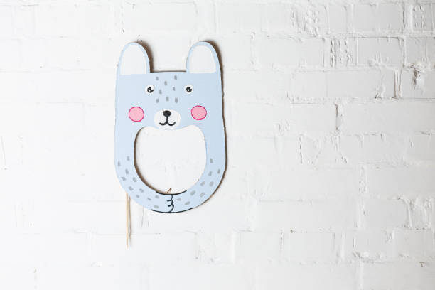 istock Bright cardboard mask on a white brick wall. 1832891775