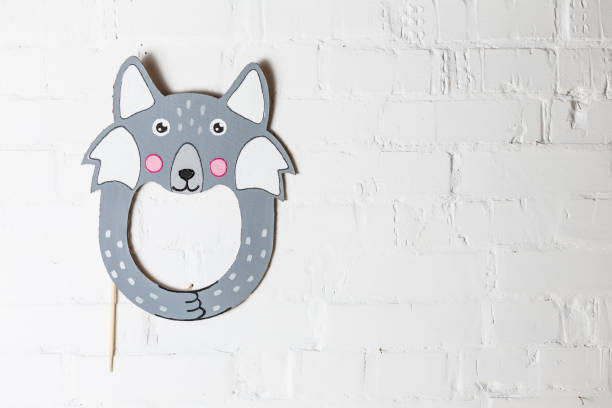 istock Bright cardboard mask on a white brick wall. 1832891776