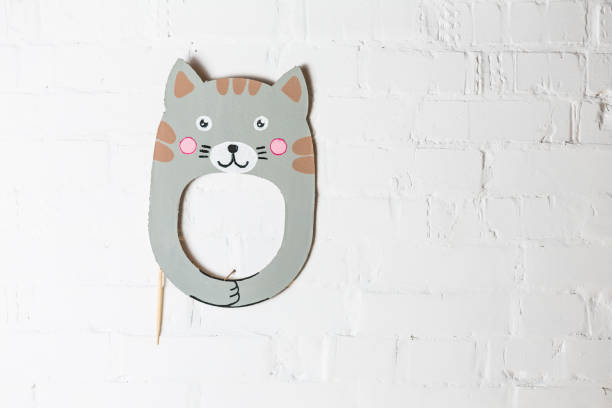 istock Bright cardboard mask on a white brick wall. 1832891777