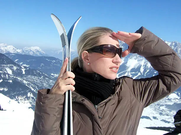 Isolated woman with sunglaces and skier looking for her friends