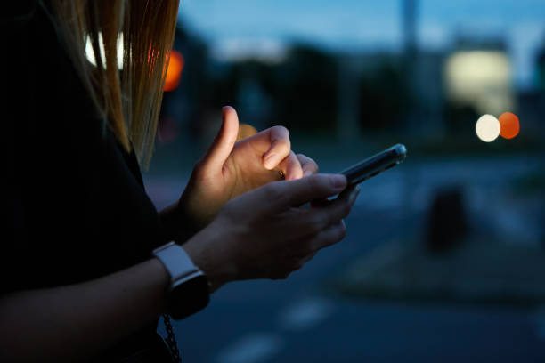 istock Woman using smartphone at evening street 1832893893