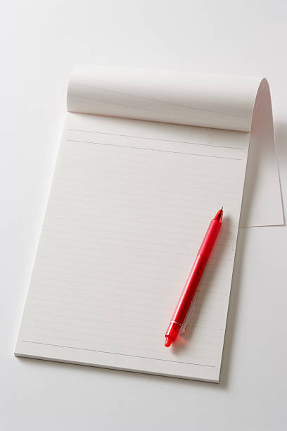 Isolated shot of blank notebook with pen on white background