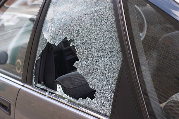 Thief broken glass in car window Cracked and crazed glass reveals the workings of a thief in the night, during the morning after. One more car crime in London. thief stock pictures, royalty-free photos & images