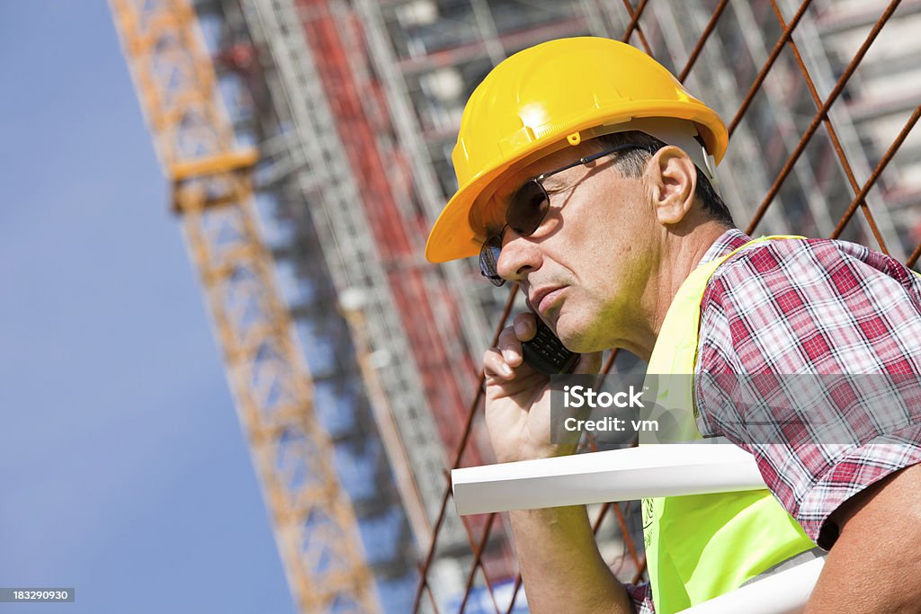 Ingegnere controlla la costruzione sito - Foto stock royalty-free di 55-59 anni